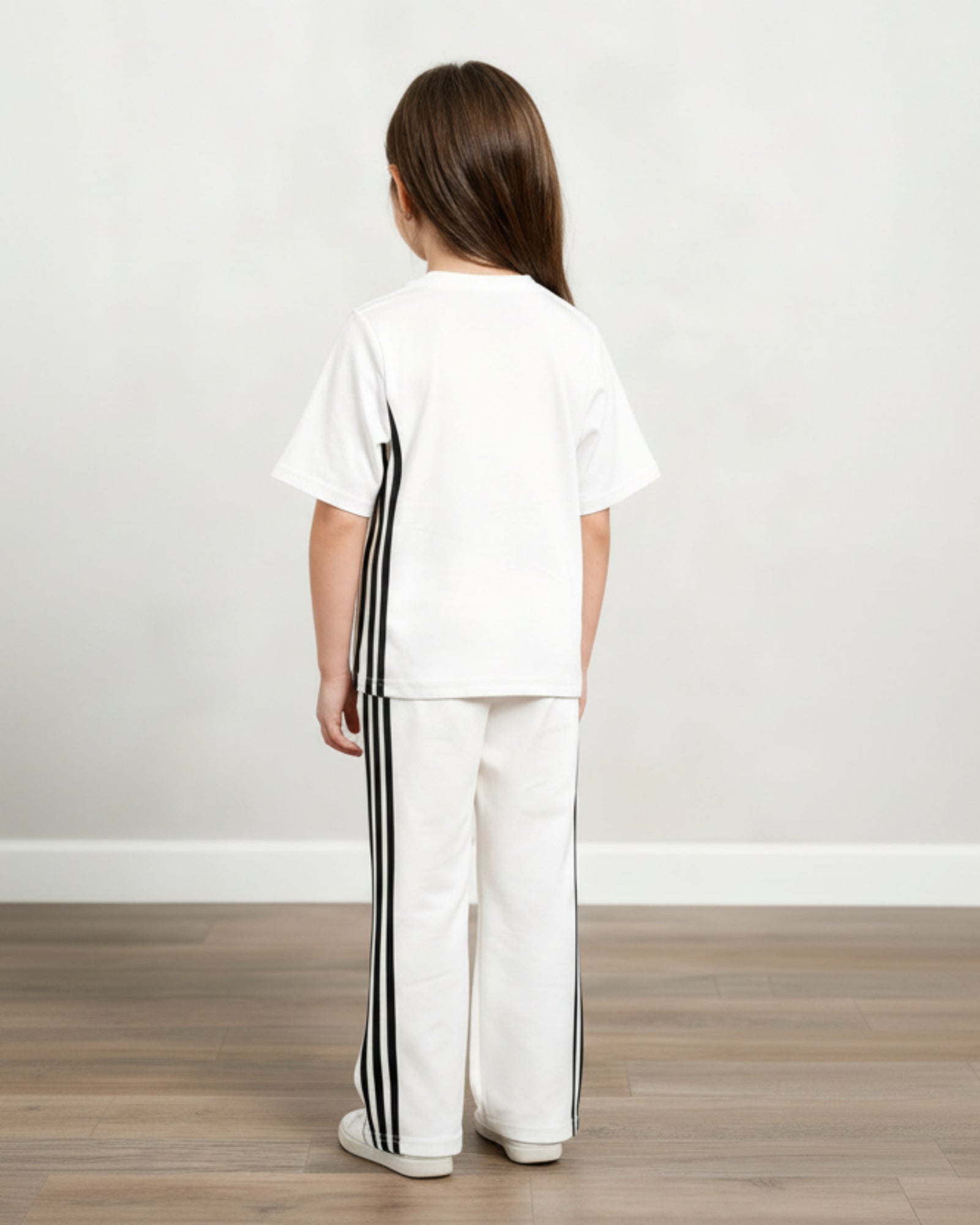 Child wearing a white outfit with black stripes on a plain background