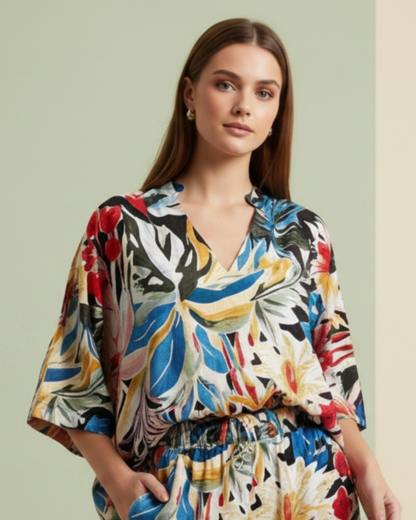 Woman wearing a colorful floral dress against a light green background
