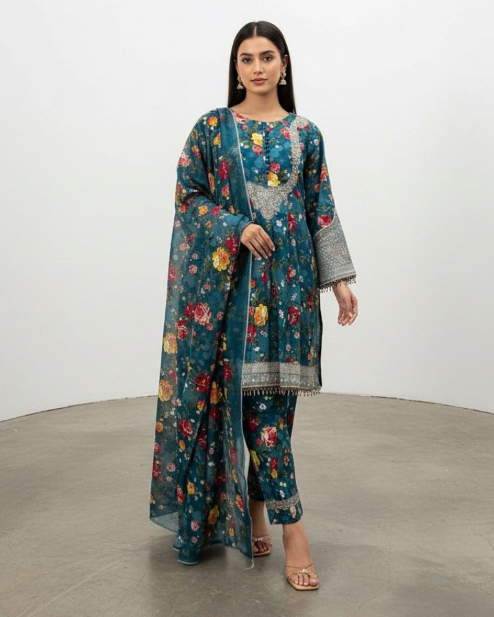 Woman wearing a floral dress with a matching jacket in a studio setting