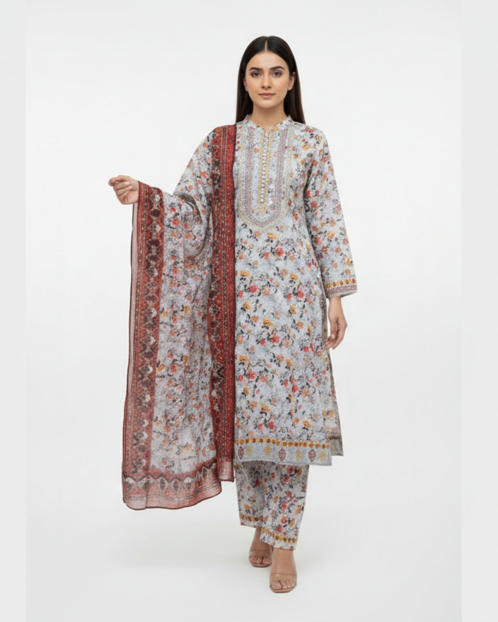 Woman wearing a floral kurta with matching pants and a long scarf on a white background
