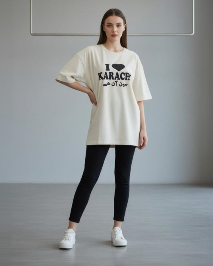 Woman wearing a white t-shirt with text, standing in a minimalistic room.