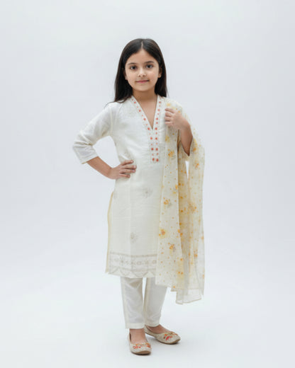 Young girl wearing a white traditional outfit with a floral dupatta on a white background