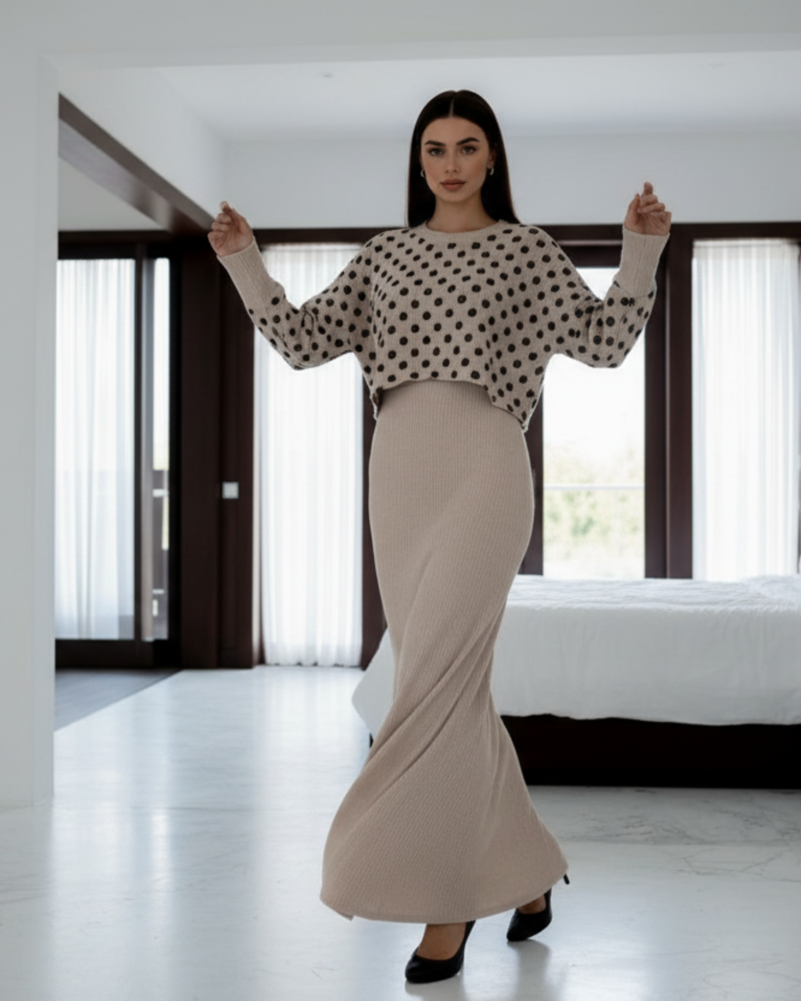 Woman wearing a polka dot blouse and beige skirt in a minimalistic setting