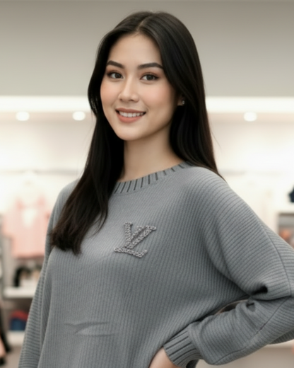 Woman wearing a gray long-sleeve top and pleated skirt in a clothing store.