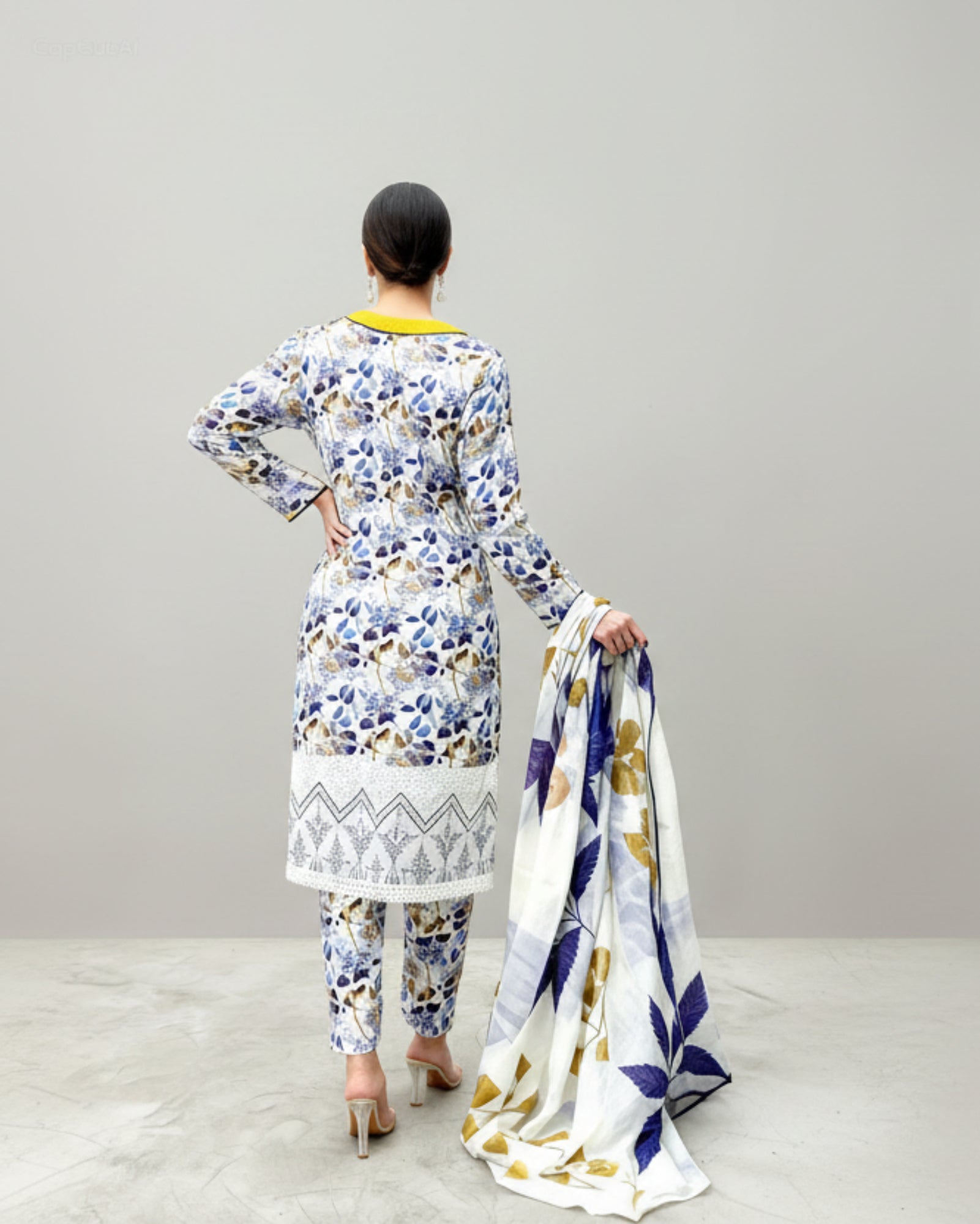 Woman wearing a floral printed outfit with a matching scarf on a white background