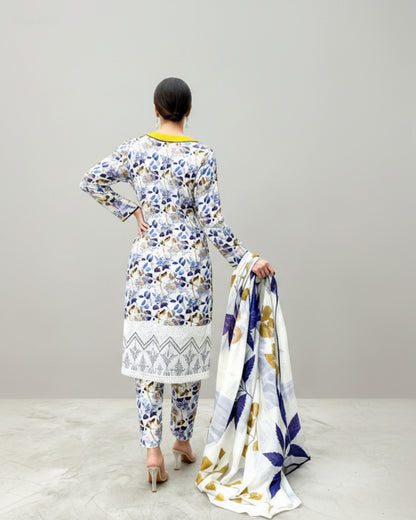 Woman wearing a floral printed outfit with a matching scarf on a white background