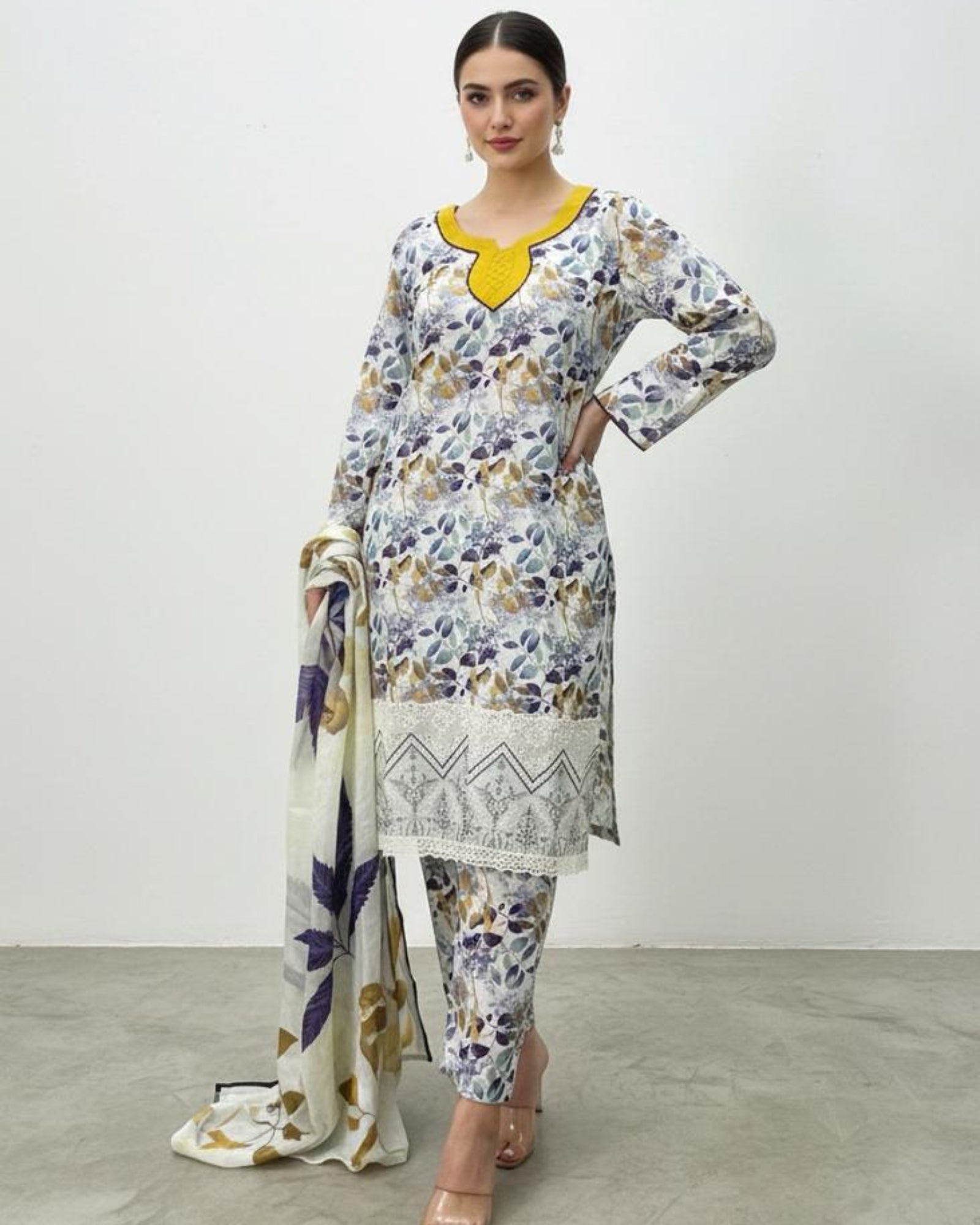 Woman wearing a floral dress with a yellow neckline and matching scarf on a white background