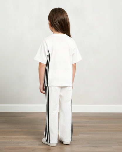 Child wearing a white outfit with black stripes on a plain background