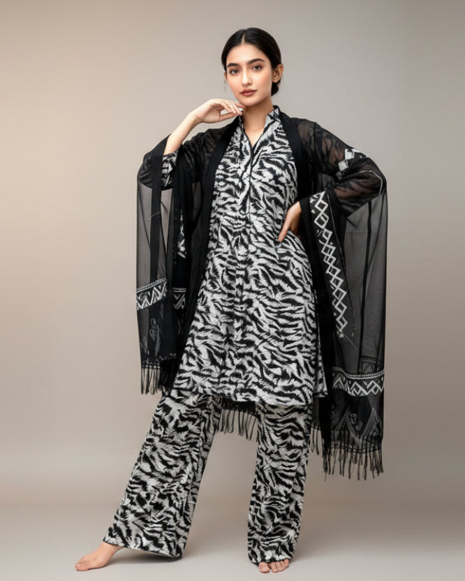 Woman wearing a black and white patterned outfit with a matching shawl on a white background